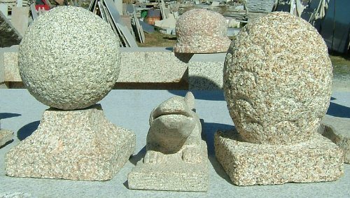 Esferas decorativos em granito. Ao centro, uma estátua de lagarto, também em granito e também produzida pela Nordemármores.